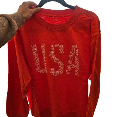 Red shirt with text held by a person 