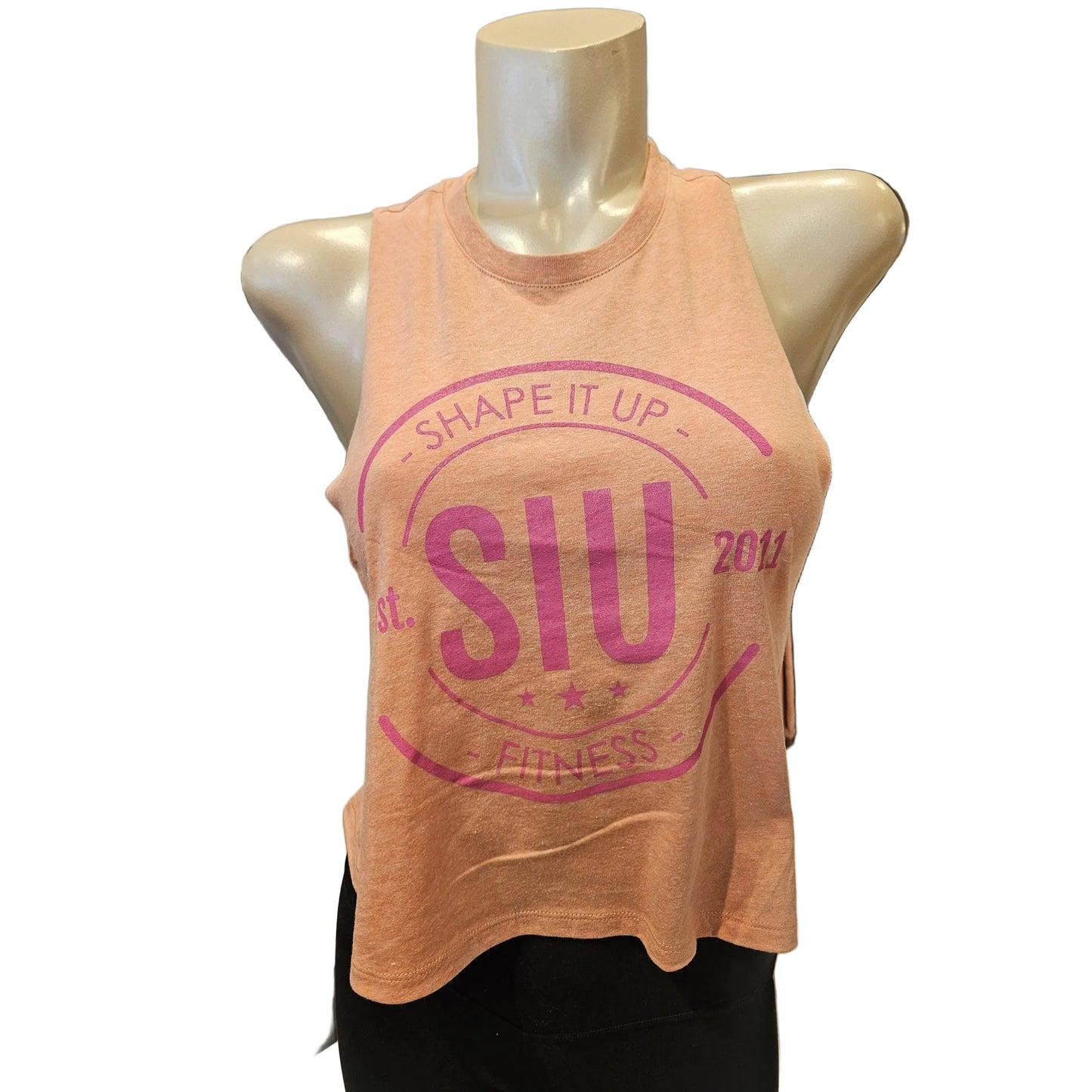 Pink tank top with 'SHAPE IT UP Fitness' text on a mannequin in a store setting.